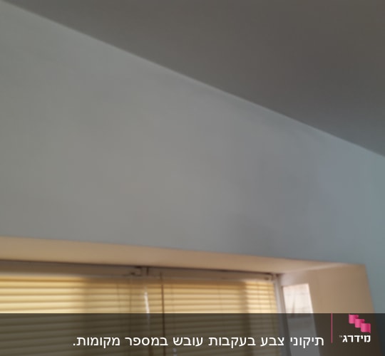 קיר צבוע בלבן ליד חלון עם תריסים